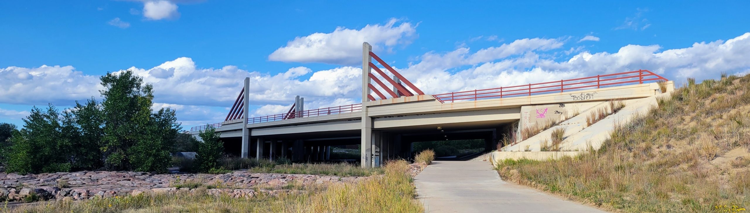 Completed bridge at Central Marksheffel with decorative red beams and surrounding roadway